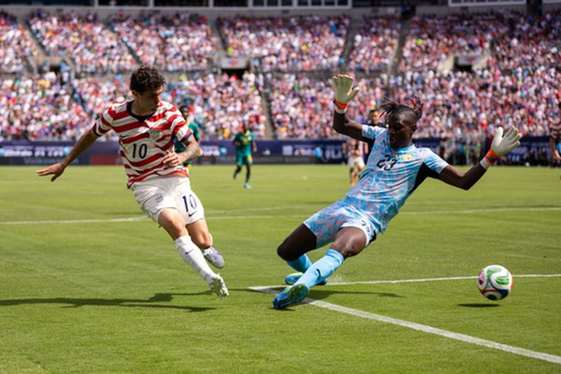 Christian Pulisic (10), delantero de Estados Unidos, dispara por entre las piernas del portero de Senegal, Cherif Ndiaye, durante el primer tiempo del partido de preparación de cara a la Copa del Mundo, el domingo 31 de mayo de 2026, en Charlotte, Carolina del Norte. (AP Foto/Scott Kinser)