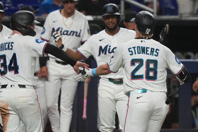Kyle Stowers (28), de los Marlins de Miami, celebra con sus compañeros de equipo después de batear un jonrón de tres carreras durante la cuarta entrada del juego de béisbol de Grandes Ligas contra los Diamondbacks de Arizona, el miércoles 10 de junio de 2026, en Miami. (AP Foto/Marta Lavandier)
