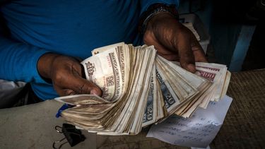 ARCHIVO - Un trabajador muestra un fajo de pesos cubanos el 11 de diciembre de 2020, en La Habana, Cuba. (AP Foto/Ramón Espinosa, Archivo)
