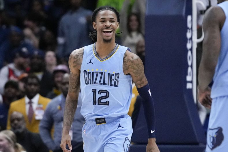 Ja Morant (12), escolta de los Grizzlies de Memphis, reacciona después de una clavada en los últimos segundos del tiempo extra durante el partido de baloncesto de la NBA en contra de los Pelicans en Nueva Orleans, el martes 26 de diciembre de 2023. Los Grizzlies ganaron 116-115. (AP Foto/Gerald Herbert)