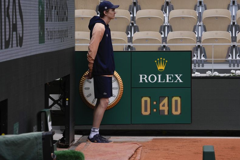 El recogepelotas frente al cronómetro que marca el tiempo que Iga Swiatek necesitó para vencer Anastasia Potapova en la cuarta ronda del Abierto de Francia, el domingo 2 de junio de 2024. (AP Foto/Thibault Camus)