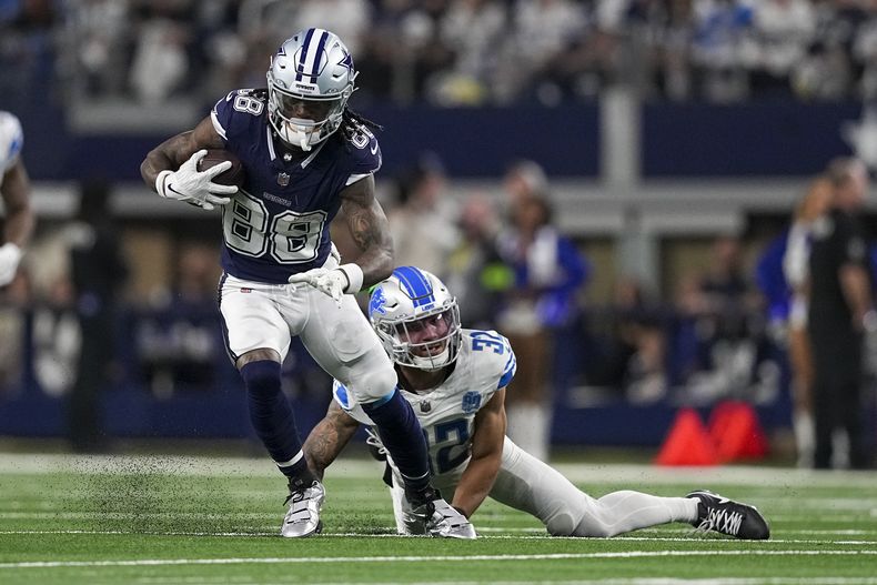 CeeDee Lamb (88), wide receiver de los Cowboys de Dallas, corre con el balón mientras el safety Brian Branch (32), de los Lions de Detroit, intenta detenerlo durante la segunda mitad del juego de la NFL, el sábado 30 de diciembre de 2023, en Arlington, Texas. (AP Foto/Sam Hodde)