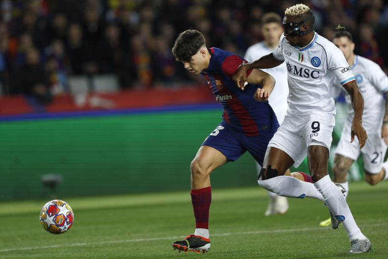 Victor Osimhen (derecha) del Napoli pugna el balón con Pau Cubarsí del Barcelona en la vuelta de los octavos de final de la Liga de Campeones, el martes 12 de marzo de 2024. (AP Foto/Joan Monfort)