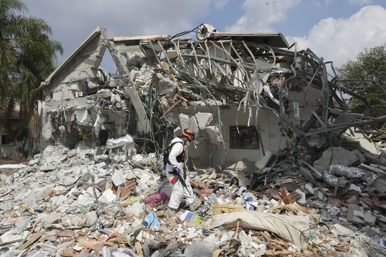 Un soldado israelí pasa junto a una vivienda destrozada por insurgentes de Hamás en el kibutz de Beeri, el 11 de octubre de 2023. El kibutz fue asaltado por miembros de Hamás durante su sorpresivo y letal asalto sobre el sur de Israel. (AP Foto/Baz Ratner)