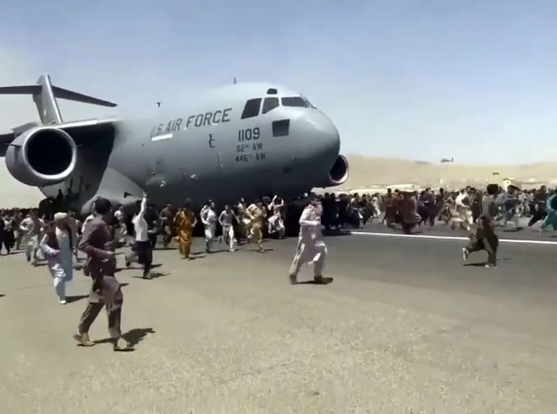 ARCHIVO - Cientos de personas desesperadas por escapar de Afganistán corren junto a un avión de la Fuerza Aérea de Estados Unidos mientras se mueve en la pista del aeropuerto internacional de Kabul, el lunes 16 de agosto de 2021. (AP Foto, Archivo)
