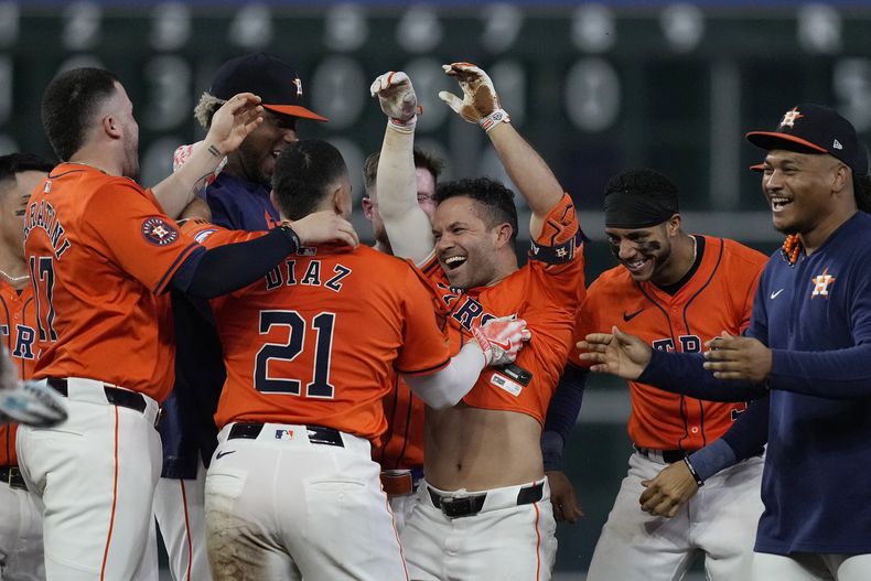 El venezolano José Altuve, de los Astros de Houston, es felicitado por sus compañeros tras remolcar la carrera del triunfo sobre los Reales de Kansas City, el viernes 30 de agosto de 2024 (AP Foto/Kevin M. Cox)