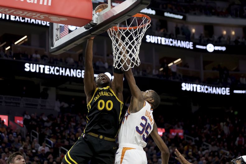 El alero de los Warriors de Golden State, Jonathan Kuminga (00), dispara contra el alero de los Suns de Phoenix, Kevin Durant (35), durante la segunda mitad del partido de baloncesto de la NBA en San Francisco, el sábado 10 de febrero de 2024. (AP Foto/Jed Jacobsohn)