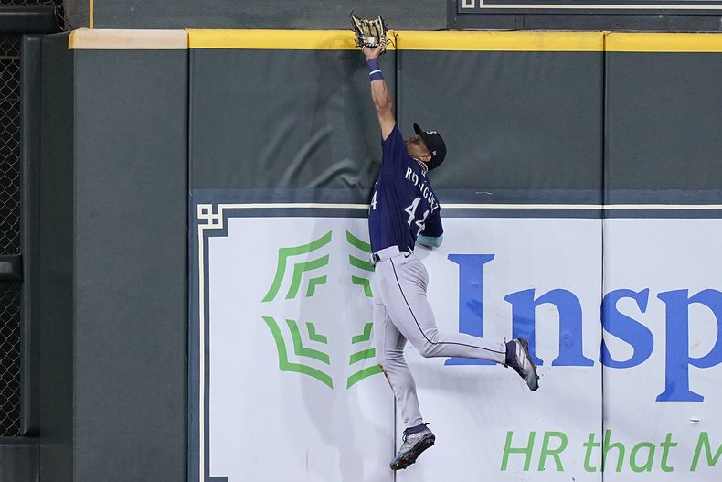 El jardinero de los Marineros de Seattle Julio Rodriguez lanza para atrapar una bola en el muro del bateador de los Astros de Houston David Hensley el viernes 7 de julio del 2023. (AP Foto/Kevin M. Cox)