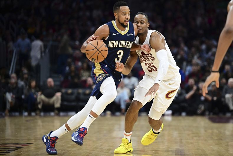 CJ McCollum, base de los Pelicans de Nueva Orleáns, conduce el balón frente a Isaac Okoro, de los Cavaliers de Cleveland, el jueves 21 de diciembre de 2023 (AP Photo/David Dermer)