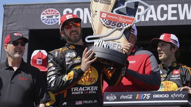Martin Truex Jr. sostiene el trofeo que lo acredita como ganador de la NASCAR Cup Series en el circuito de Sonoma, el domingo 11 de junio de 2023, en Sonoma, California. (AP Foto/Darren Yamashita)