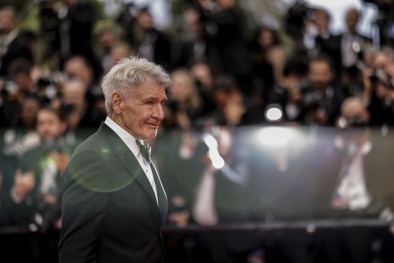 Harrison Ford posa a su llegada al estreno de la película Indiana Jones and the Dial of Destiny en la 76a edición del festival internacional de cine de Cannes, en sur de Francia, el jueves 18 de mayo de 2023. (Foto Vianney Le Caer/Invision/AP)