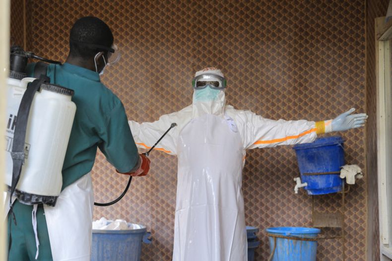 Un trabajador sanitario, vestido con un equipo de protección, es desinfectado por un compañero en el interior de un centro de tratamiento para pacientes con ébola, en Beni, en la provincia de Kivu Norte, en el este de República Democrática de Congo, el 26 de septiembre de 2026. (AP Foto/Sebastien Kitsa Musayi)