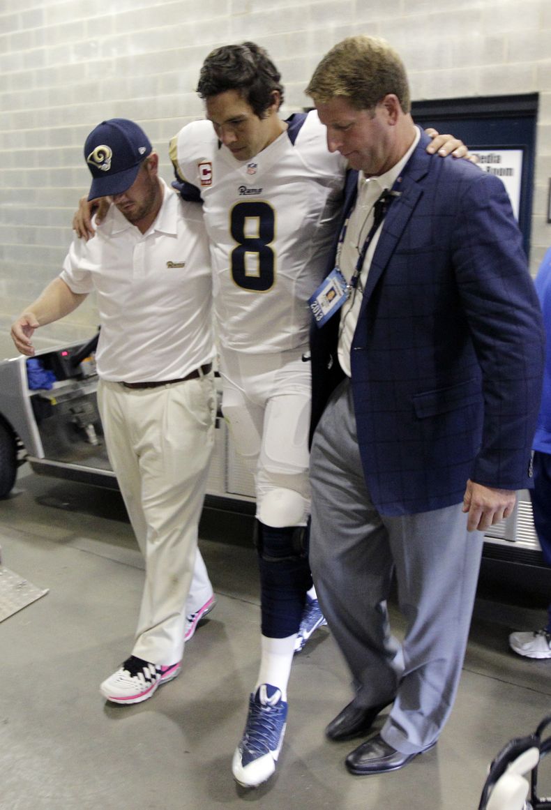 El querterback de los Rams Sam Bradford (8) es ayudado a llegar a los vestuarios tras lesionarse una pierna contra Carolina el 20 de octubre del 2013. Se confirm&oacute; que Bradford sufri&oacute; una rotura de los ligamentos de la rodilla izquierda y no