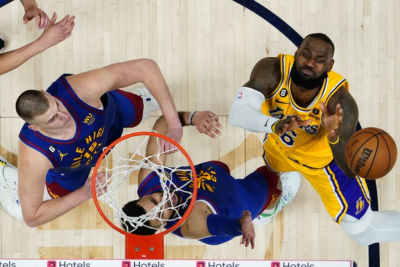 LeBron James (6), de los Lakers de Los Ángeles, pierde el balón mientras que Nikola Jokic (15) y Jamal Murray, centro, de los Nuggets de Denver, defienden durante la segunda mitad del Juego 1 de las Finales de la Conferencia Oeste, el martes 16 de mayo de 2023, en Denver. Los Nuggets derrotaron a los Lakers 132-126. (AP Photo/Jack Dempsey)