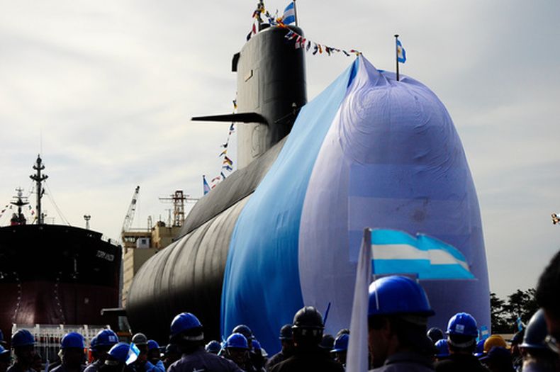 ARCHIVO - Unos trabajadores posan junto al submarino ARA San Juan durante una ceremonia para celebrar la primera fase de las reparaciones a gran escala en el Complejo Industrial Naval Argentino (CINAR) de Buenos Aires, el 27 de septiembre de 2011. (Foto AP/Mario de Fina, archivo)