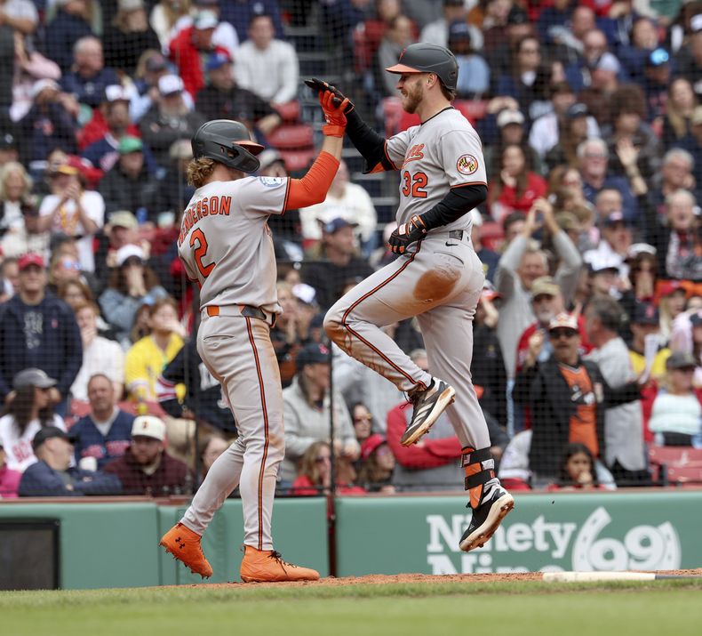 El bateador designado de los Orioles de Baltimore Ryan OHearn le da los cinco a su compañero Gunnar Henderson tras anotar en dos errores de los Medias Rojas de Boston en la octava entrada del juego del domingo 25 de mayo del 2025. (AP Foto/Mark Stockwell)