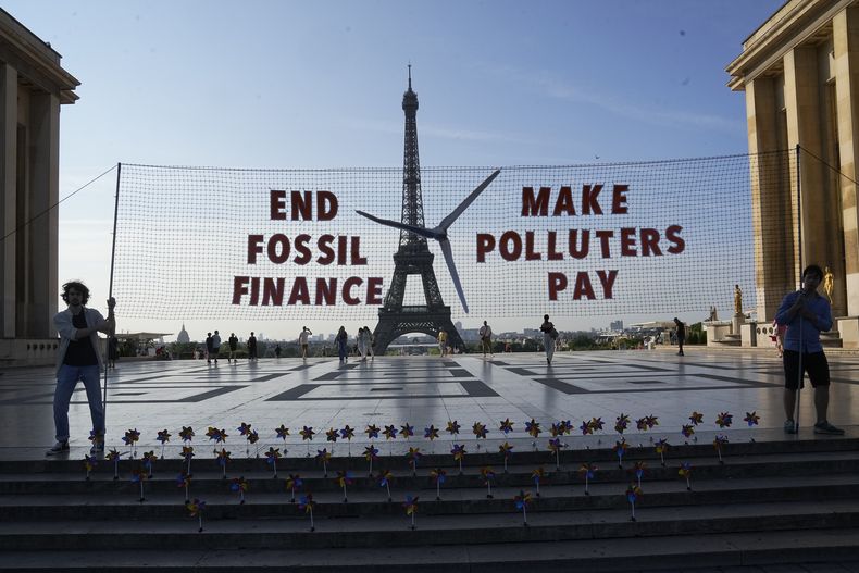 ARCHIVO - Activistas participan en una manifestación antes de la Cumbre para un Nuevo Pacto Financiero Mundial en París, el miércoles 21 de junio de 2023. Líderes mundiales, jefes de organizaciones internacionales y activistas se reunieron en París para buscar formas mejores de combatir problemas de cambio climático y pobreza reformulando el sistema financiero global. (AP Foto/Michel Euler, Archivo)