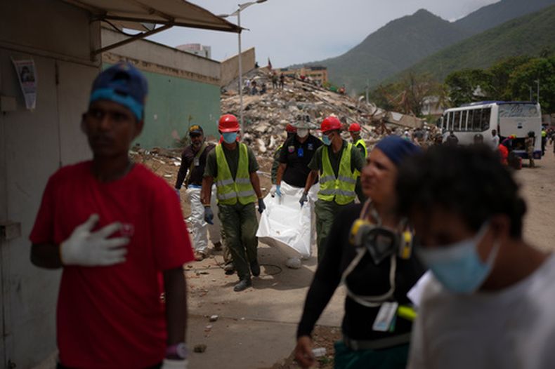 Equipos de rescate y el técnico forense Joel Mirabal, atrás a la izquierda, recuperan el cuerpo de una víctima del terremoto en La Guaira, Venezuela, el 30 de junio de 2026. (Foto AP/Matías Delacroix)