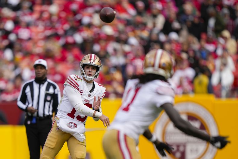 El quarterback de los 49ers de San Francisco Brock Purdy lanza un pase al receptor Brandon Aiyuk en el encuentro ante los Commanders de Washington el domingo 31 de diciembre del 2023. (AP Foto/Mark Schiefelbein)