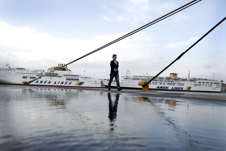 Una mujer camina frente a barcos amarrados en el puerto del Pireo, cerca de Atenas, durante una huelga general de 24 horas en protesta por medidas de austeridad adicionales, el mi&eacute;rcoles 6 de noviembre de 2013. (AP Foto/Petros Giannakouris)