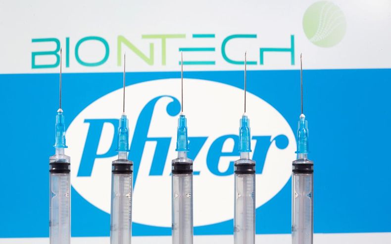 FILE PHOTO_ Syringes are seen in front of displayed Biontech and Pfizer logos in this illustration.jpeg