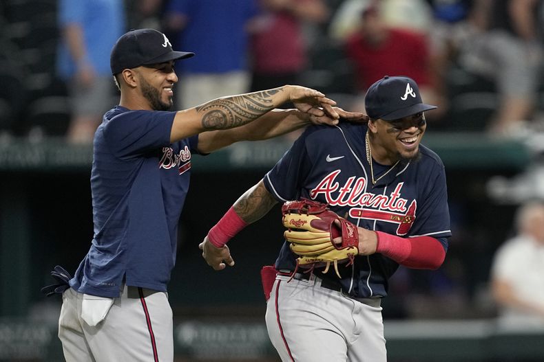 El puertorriqueño Eddie Rosario (izquierda) y el venezolano Orlando Arcia, de los Bravos de Atlanta, festejan el triunfo por 6-4 ante los Rangers de Texas, el miércoles 17 de mayo de 2023 (AP Foto/Tony Gutiérrez)