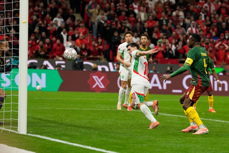 Brahim Díaz (derecha) anota el primer gol de Marruecos en la victoria 2-0 ante Camerún en los cuartos de final de la Copa Africana de Naciones, el viernes 9 de enero de 2026, en Rabat. (AP Foto/Mosaab Elshamy)