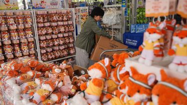 Una trabajadora prepara muñecos de felpa para vender en una tienda de recuerdos durante el torneo de tenis Abierto de China, en Beijing, el miércoles 30 de septiembre de 2026. (AP Foto/Andy Wong)