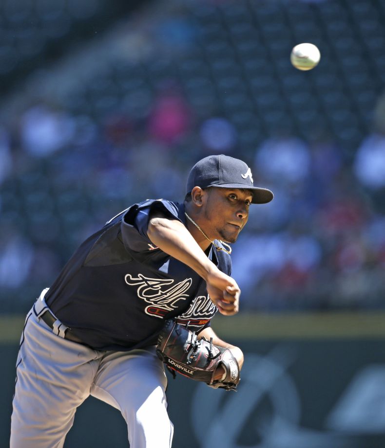 Julio Teher&aacute;n de los Bravos de Atlanta lanza ante los Marineros de Seattle el mi&eacute;rcoles 6 de agosto de 2014. (AP Foto/Elaine Thompson)