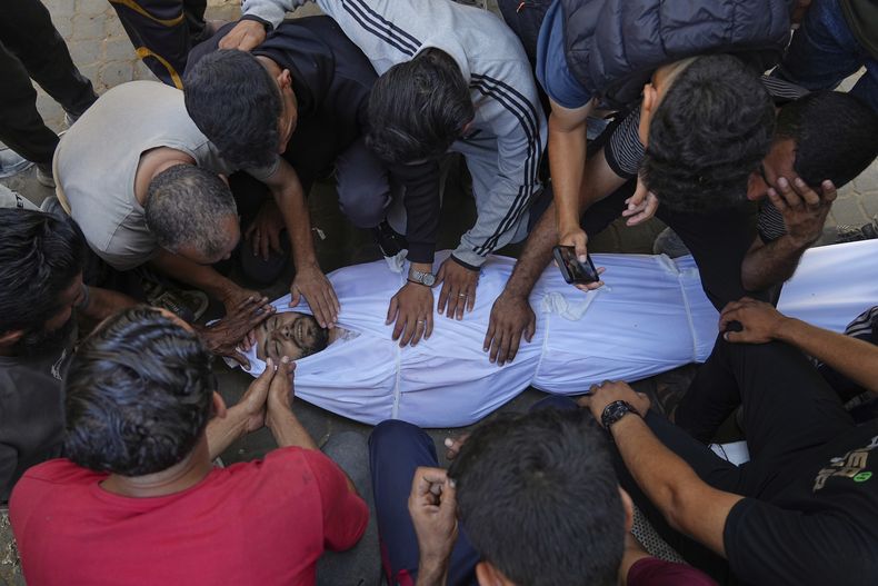 Familiares lloran sobre el cuerpo del palestino Bilal Abu Amsha, asesinado con otras personas en ataques aéreos israelíes en la Franja de Gaza, en el hospital de Al-Shifa en Ciudad de Gaza, el sábado 28 de junio de 2025. (AP Foto/Jehad Alshrafi)