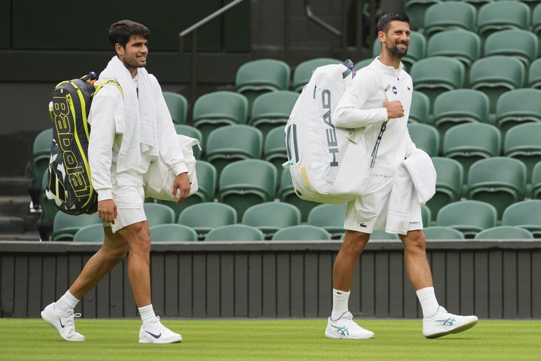 Novak Djokovic de Serbia, derecha, y Carlos Alcaraz de España, izquierda, llegan para una sesión de práctica en la Cancha Central del All England Lawn Tennis and Croquet Club, antes del Campeonato de Wimbledon en Londres, el jueves 26 de junio de 2025. (AP Photo/Kirsty Wigglesworth)