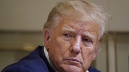 ARCHIVO - El expresidente Donald Trump escucha a reporteros en su avión mientras se dirigía a West Palm Beach, Florida, el 25 de marzo de 2023 tras efectuar un mitin de campaña en el Aeropuerto Regional de Waco, Texas. (AP Foto/Evan Vucci, archivo)