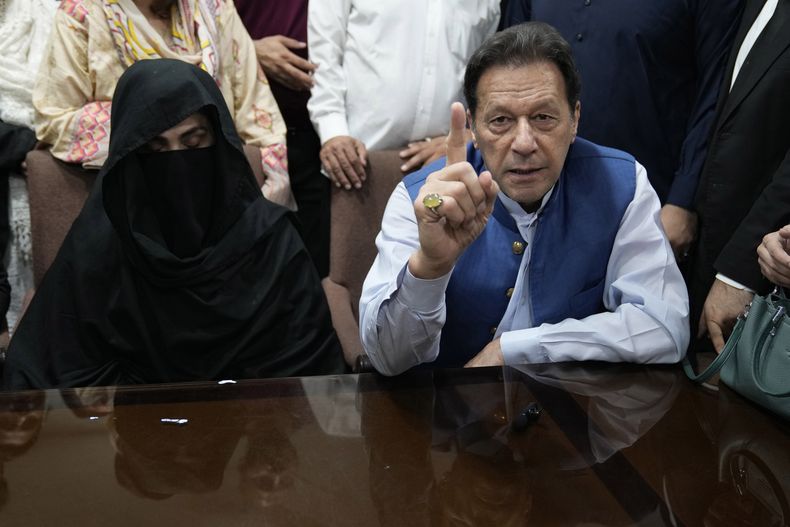 ARCHIVO - El exprimer ministro de Pakistán Imran Khan, y Bushra Bibi, su esposa, hablan con los medios en una oficina del Tribunal Superior de Lahore, en Pakistán, el 17 de julio de 2023. (AP Foto/K.M. Chaudary, Archivo)