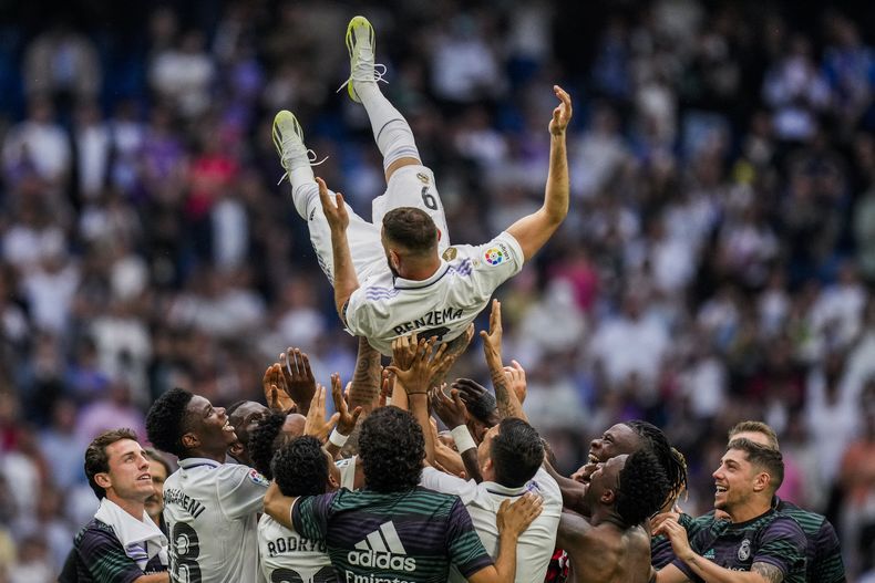 Karim Benzema del Real Madrid es alzado por sus compañeros tras el empate 1-1 contra el Athletic Bilbao en la Liga española, el domingo 4 de junio de 2023, en Madrid. (AP Foto/Bernat Armangue)