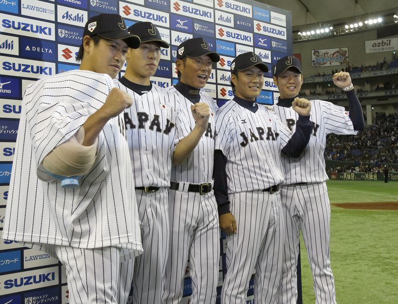 El manager de Jap&oacute;n, Hiroki Kokubo, centro, posa con los lanzadores, de izquierda a derecha,  Kazuhisa Makita, Yuji Nishino, Takahiro Norimoto y Yuki Nishi tras vencer a una selecci&oacute;n de Grandes Ligas, sin permitir hits, el s&aacute;bado, 15