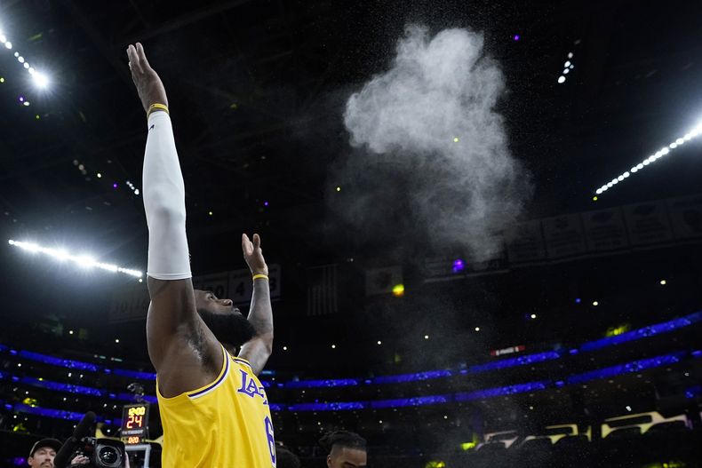 En foto del 8 de mayo del 2023, el alero de los Lakers de Los Ángeles LeBron James lanza polvo blanco al aire antes del juego 4 de las semifinales de la Conferencia Oeste ante los Warriors de Golden State. (AP Foto/Marcio Jose Sanchez)