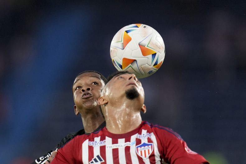 Yarlen (izquierda), de Botafogo de Brasil, y Edwin Herrera, de Junior de Colombia, disputan un centro en un partido de la Copa Libertadores, el martes 28 de mayo de 2024 (AP Foto/Fernando Vergara)