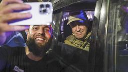Yevgeny Prigozhin, propietario de la compañía militar Grupo Wagner, a la derecha, se sienta en un vehículo militar y posa para una selfie con un civil en una calle de Rostov en el Don, Rusia,e l sábado 24 de junio de 2023 antes de abandonar una zona del cuartel general del Distrito Militar Sur de Rusia. (AP Foto)
