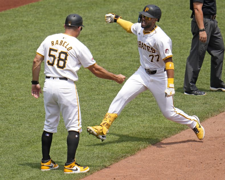 Joshua Palacios (77), de los Piratas de Pittsburgh, da vuelta por tercera frente al coach Mike Rabelo (58) después de conectar un jonrón solitario ante el lanzador relevista de los Mets de Nueva York, Adrian Houser, durante la sexta entrada en Pittsburgh, el lunes 8 de julio de 2024. Los Piratas ganaron 8-2. (AP Foto/Gene J. Puskar)
