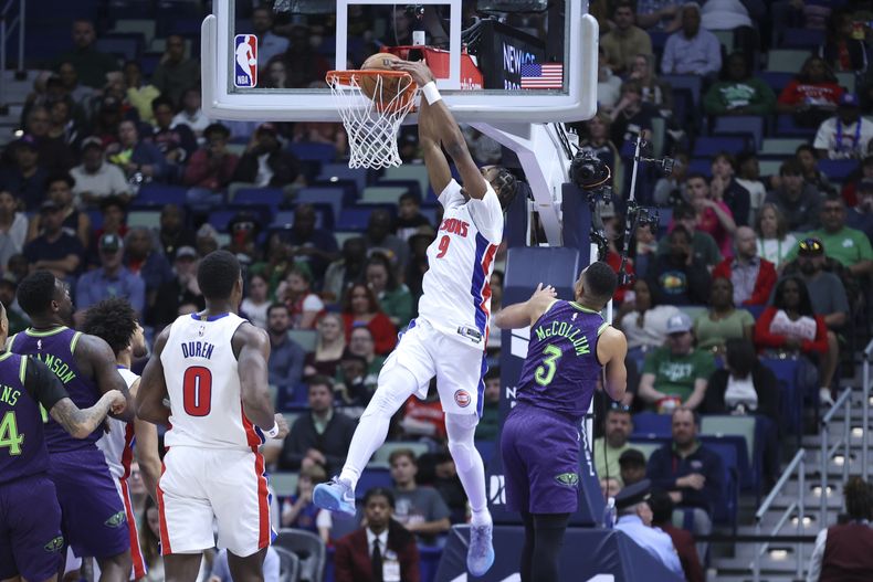 El alero de los Pistons de Detroit Ausar Thompson clava el balón frente al base de los Pelicans de Nueva Orleans CJ McCollum en el encuentro de la NBA del lunes 17 de marzo del 2025. (AP Foto/Peter Forest)