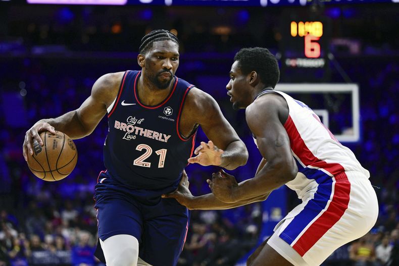 Joel Embiid de los 76ers de Filadelfia driblea el balón superando a Jalen Duren de los Pistons de Detroit en el encuentro de la NBA del martes 9 de abril del 2024. (AP Foto/Derik Hamilton)