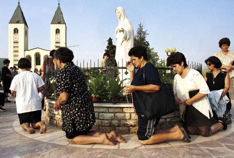 Fieles de la iglesia católica bosnia rezan durante la fiesta de la Asunción en Medjugorje, a unos 120 kilómetros (75 millas) al sur de la capital de Bosnia, Sarajevo, el 15 de agosto de 2000. (AP Foto/Hidajet Delic, archivo)