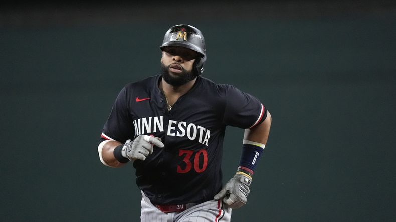 El dominicano de los Mellizos de Minnesota, Carlos Santana recorre las bases tras su cuadrangular en el que también anotaron sus compañeros Ryan Jeffers y Manuel Margot durante la quinta entrada del juego de béisbol ante los Rangers de Texas, en Arlington, Texas, el viernes 16 de agosto de 2024. (AP Foto/LM Otero)