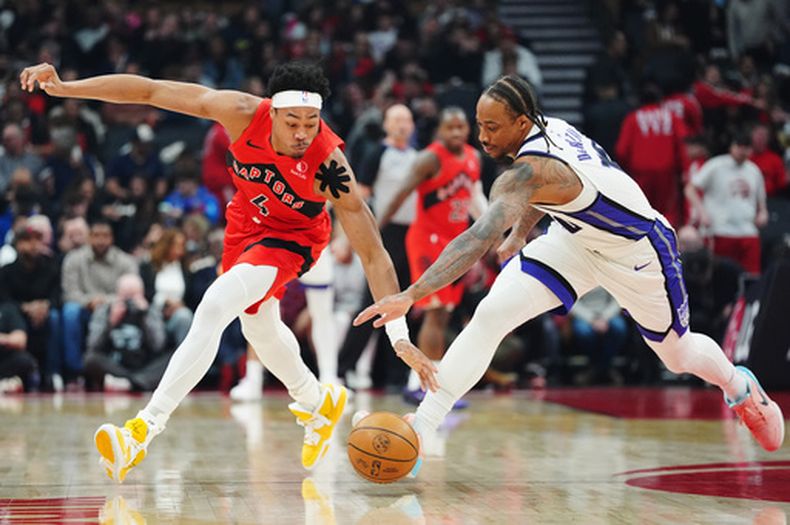 Scottie Barnes, de los Raptors de Toronto, y DeMar DeRozan, de los Kings de Sacramento, disputan un balón en el partido del miércoles 1 de abril de 2026 (Frank Gunn/The Canadian Press via AP)