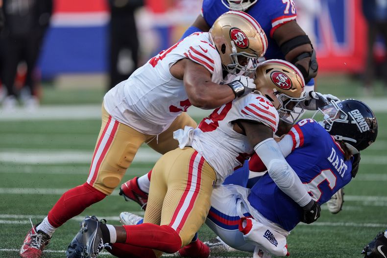 Jaxson Dart (6), quarterback de los Giants de Nueva York, es tackleado por Tatum Bethune (48), linebacker de los 49ers de San Francisco, durante el tercer cuarto de un juego de fútbol americano de la NFL, el domingo 2 de noviembre de 2025, en East Rutherford, Nueva Jersey. (AP Photo/Seth Wenig)