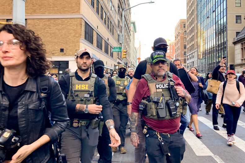 Agentes federales caminan por Lafayette Street seguidos por manifestantes tras una redada de inmigración en Canal Street a través de Chinatown, el martes 21 de octubre de 2025, en Nueva York. (AP Foto/Jake Offenhartz)