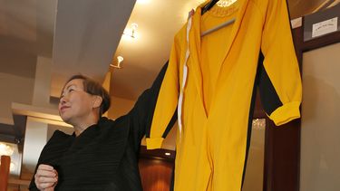 americateve | Anna Lee, vicepresidenta de la casa de subastas Spink, muestra el traje amarillo que la leyenda de las artes marciales Bruce Lee visti&oacute; en la pel&iacute;cula "Game of Death", el lunes 2 de diciembre de 2013. La prenda se subast&oacute; en