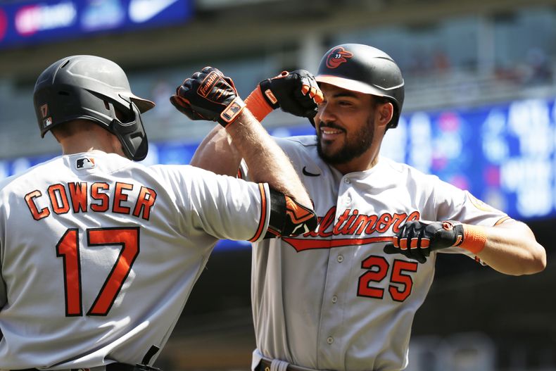 Anthony Santander (25), de los Orioles de Baltimore, celebra con Colton Cowser (17) después de batear cuadrangular en la séptima entrada en el juego de béisbol, el domingo 9 de julio de 2023, en Minneapolis. (AP Foto/Andy Clayton-King)