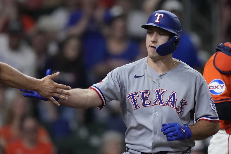 Wyatt Langford, de los Rangers de Texas, es felicitado luego de batear un jonrón de dos carreras ante los Astros de Houston, el viernes 11 de julio de 2025 (AP Foto/Kevin M. Cox)