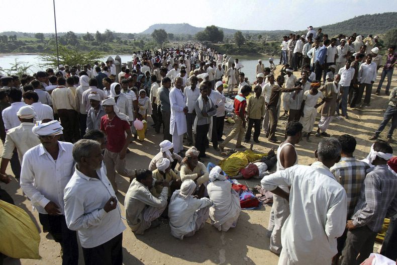 Varias personas se re&uacute;nen despu&eacute;s de una estampida de personas que dej&oacute; al menos 109 muertos en un puente que cruza el r&iacute;o Sindh en el distrito de Datia, en Madhya Pradesh, el domingo 13 de octubre de 2013. (AP Foto)